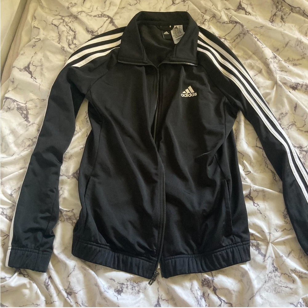 Classic black Adidas track jacket with white 3-stripe detail down the sleeves.